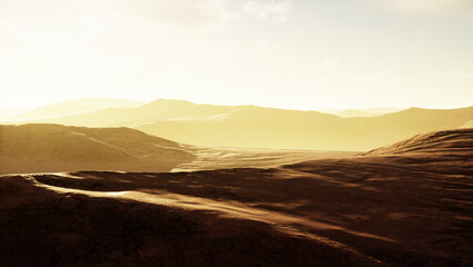 Soft golden light fills the air as dawn breaks over a tranquil valley. The gentle curves of the...