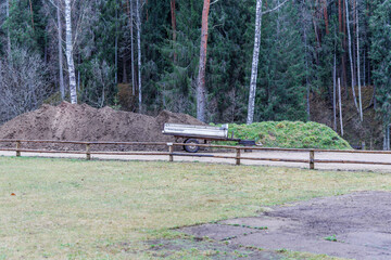 Farm Paddock with Dirt Piles and Utility Trailer