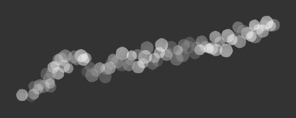 Abstract bokeh light trail with glowing sparkle particles on dark background