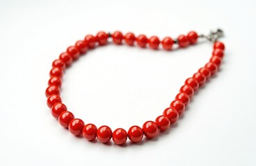 Obraz premium Red coral beads necklace isolated on white studio background. Natural jewelry, precious gems, luxury accessory for women. Fashion, beauty, elegance, luxury statement piece.