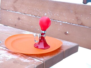 Red bicycle horn on an orange sled, winter fun for kid. Outdoor toy for play activity in cold...