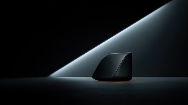 A sleek black device illuminated by a dramatic light beam in a minimalist dark setting