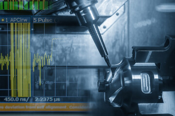 Abstract 5-axis CNC milling machine cutting the automotive part and graph display background in the light blue scene.