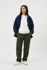 Full-length portrait of a stylish woman in a casual outfit: navy jacket, white sweatshirt, and olive pants. Modern minimalist fashion isolated on white.