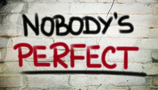 The phrase 'Nobody's Perfect' boldly spray-painted in black and red on a textured brick wall, conveying a universal message of self-acceptance