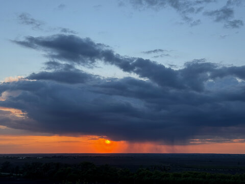 Sunset creating orange glow under rain clouds