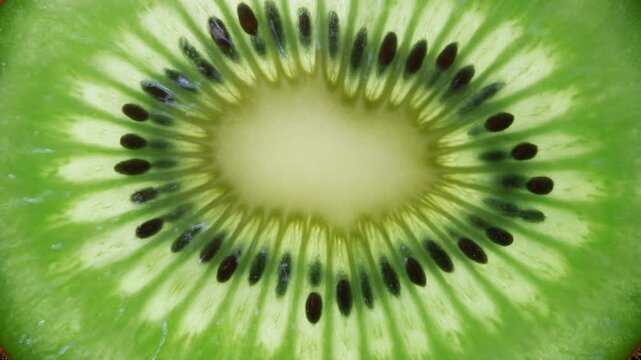 Detailed view of a fresh kiwi fruit slice showcasing its vibrant green flesh and black seeds