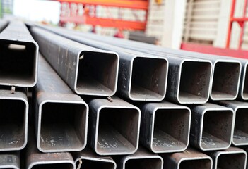 Close-Up of Stacked Steel Pipes or Square Hollow in Industrial Warehouse
