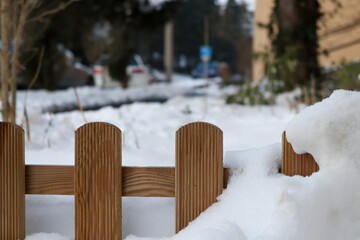 Wooden garden fence partially covered in deep winter snow