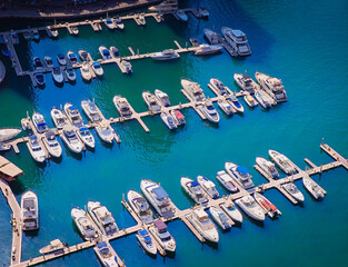 Aerial drone view of Dubai Marina harbor with many luxury yachts, capturing modern waterfront and city skyline. Floating boats on canal