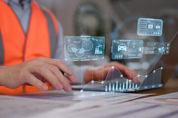 Engineer wearing safety vest using computer and analysing documents data with virtual diagram of green and sustainable business energy