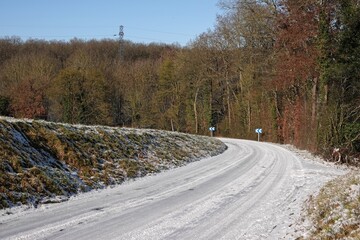Route de campagne enneig&eacute;e par temps ensoleill&eacute; en hiver