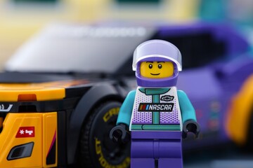 Obraz premium Tambov, Russian Federation - January 02, 2026 Portrait of a Lego NASCAR Next Gen Chevrolet Camaro ZL1 driver minifigure standing near his car. LEGO Speed Champions.