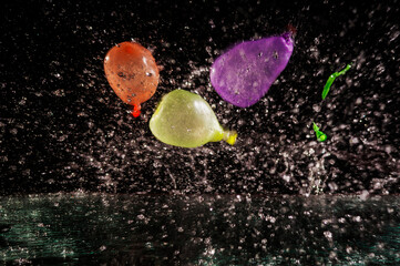 Three colorful water balloons squirting
