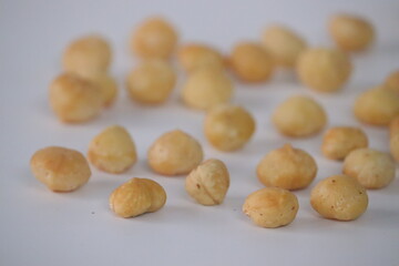 Fototapeta premium Roasted macadamia nuts presented in a rustic close-up scatter, featuring whole shelled kernels