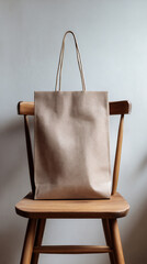 Gift bag hanging on chair, vertical frame, neutral wall with copy space.