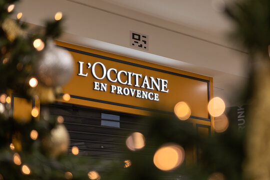 Krakow, Poland - November 30, 2025: L'Occitane en Provence store sign prominently glows, illuminating closed retail business, framed by soft festive holiday bokeh lights