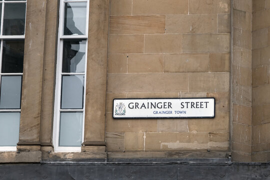 Grainger Street sign on a historic stone facade in Grainger Town, Newcastle, highlighting neoclassical urban architecture.