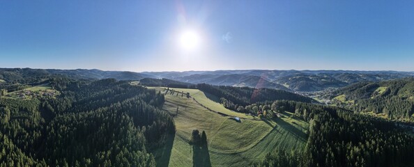Obraz premium Aerial drone view of the village of Velké Karlovice, Moravia, Czech Republic. Sunny day in the Beskydy Mountains, view of forested hills, meadows and a small town.