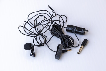Components of a Boya BY-M1 omnidirectional lavalier condenser microphone kit with 6m cable, 3.5mm jack, 1/4" adapter, and power module on white background.