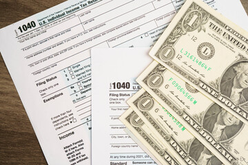 Tax form 1040 U.S. Individual Income Tax Return with dollar banknotes money.