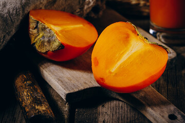 A group of ripe orange persimmon fruits.Persimmon fruits on a wooden board, rustic background