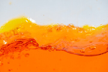 Vibrant orange liquid splashing, creating dynamic waves and droplets. High-speed abstract action shot perfect for beverage, juice, soda, or energy drink advertising and refreshment promotion