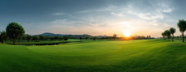 Scenic golf course landscape at sunset with rolling green hills and clear sky