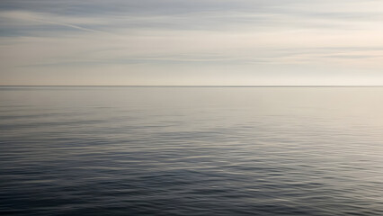 Cloudy overcast sky reflected on a calm water surface