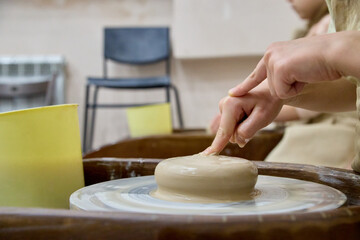 Hands shaping wet clay on a spinning pottery wheel, capturing focus, tactile texture, and the authentic atmosphere of a creative artisan workshop.