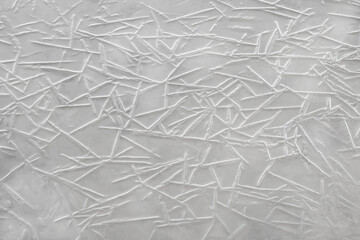 A geometric pattern of frozen water crystals. Gray background. Top view.