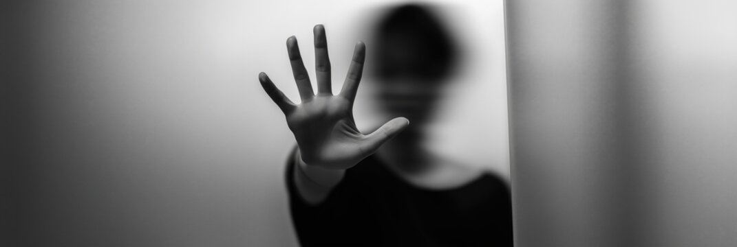 Silhouette of female asian young adult with hand raised in stop gesture
