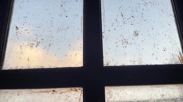 Dirty window glass with morning sky light seen from inside