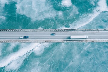 Aerial View of Vehicles on a Bridge over Frozen Water, Highlighting Winter's Hardships