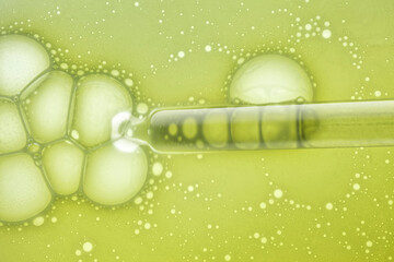 Liquid pipette oil or serum elixir cool emerald green on light green colored translucent background