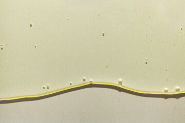 Cream gel yellow transparent cosmetic sample texture with bubbles on golden metallic background