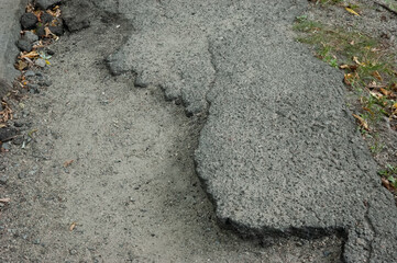 Old cracked gray asphalt surface conveying abandonment and neglect.