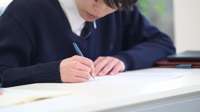 学校や塾などで受験対策の模試のテストを受ける高校生の男子の顔無しの動画