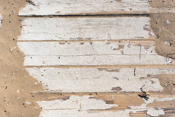 White paint peeled off worn wooden planks of the beach board walk in Sunny beach Bulgaria. Suitable for background texture