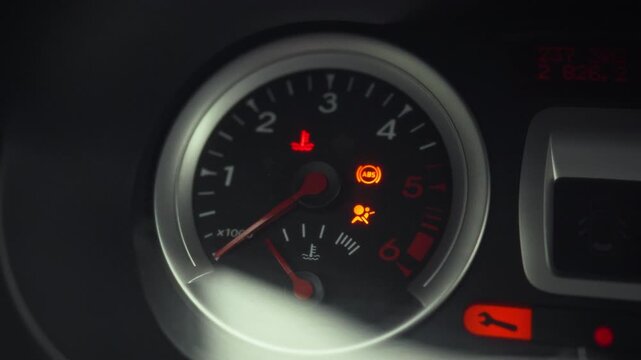 The driver turns ignition key, initiating car's startup sequence, as warning lights illuminate on the dashboard, signaling the engine is about to roar to life, and the vehicle prepares for operation