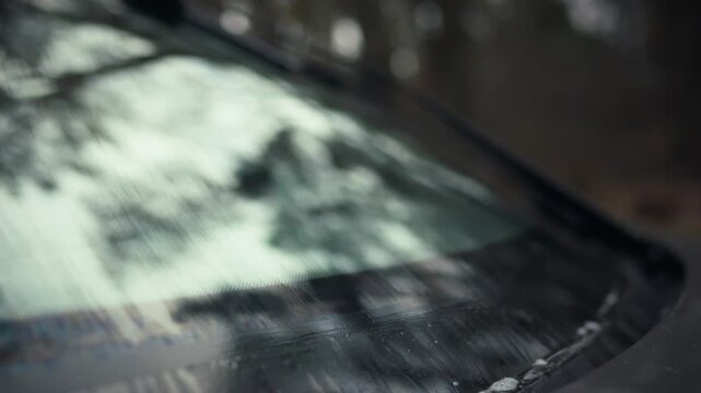 Automotive front windshield wipers on a vehicle swiftly move, clearing dirt and grime, thereby providing an unobstructed view through the glass surface, ensuring a safe drive with optimal visibility