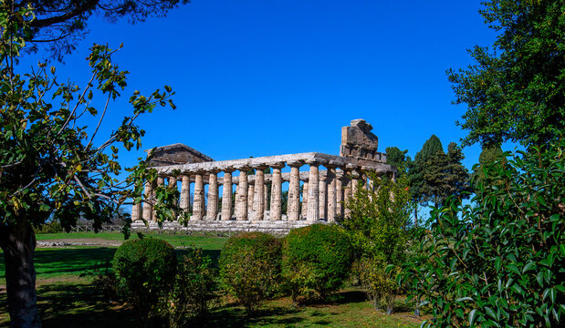 Ancient Greek Temple of Athena in Paestum, Italy at sunny day with blue sky. Famous archaeological site of Paestum, Magna Graecia, ancient ruins.