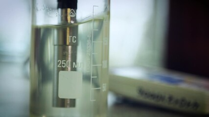 Close-up of a test tube into which a special device is lowered for testing in a liquid.