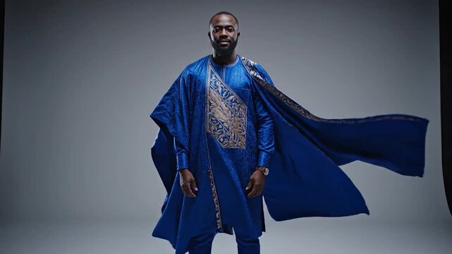 Confident African Man in Traditional Blue Agbada Robe Posing in Studio.