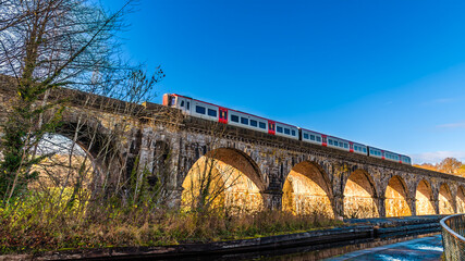 A view past the canal aqueduct towards train on the railway viaduct over the River Ceiriog at Chirk, Wales