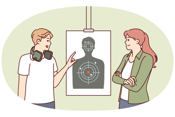 Man teaches woman to shoot at targets with rifle range of firearms for admission to police academy. Girl attends shooting classes in rifle range, training to use pistol or rifle for self-defense
