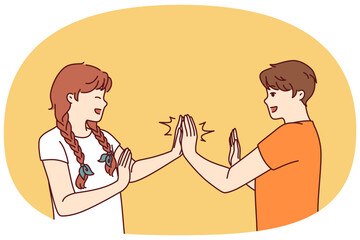 Fototapeta premium Children play hand-clapping laughing and enjoying teenage friendship and happy childhood. Boy and girl play hand-clapping after school for concept of children socialization through active games