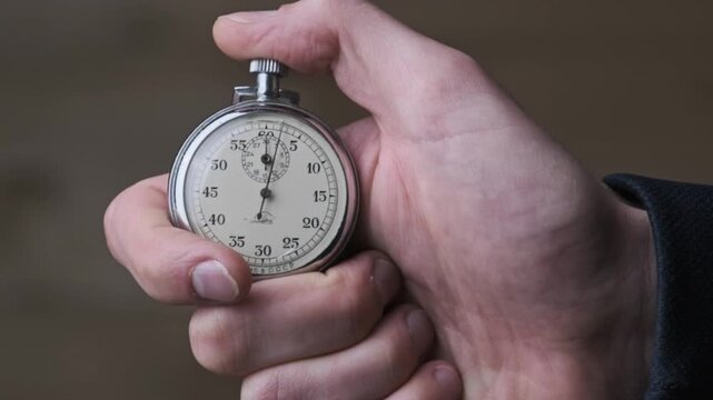 Person holding a stopwatch in their hand very tightly