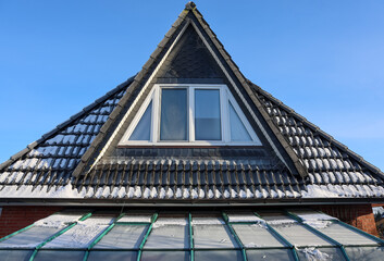 House roof dormer window collecting fresh winter snow