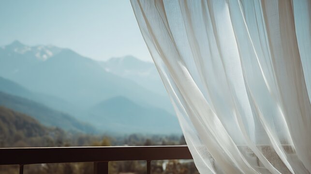 Sheer white curtain gently blowing, framing a view of mountain range and lush valley - Powered by Adobe